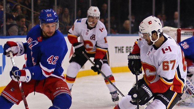 Brendan Smith (42) z New York Rangers a Michael Frolk (67) z Calgary zpol o puk.