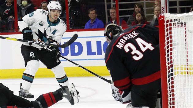 Logan Couture ze San Jose pl, esk brank ve slubch Caroliny Petr Mrzek zasahuje.