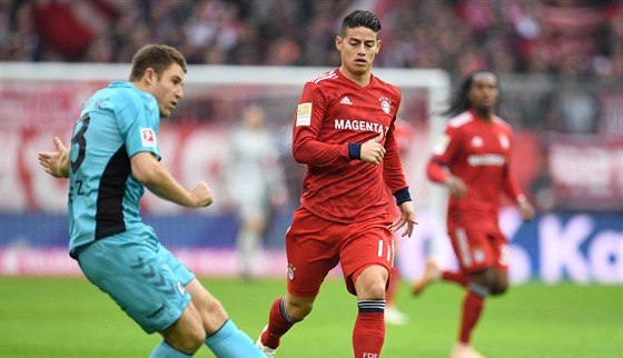 Branká Freiburgu Mike Frantz rozehrává ped Jamesem Rodríguezem z Bayernu...
