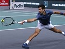 Srb Novak Djokovi se ve finále turnaje v Paíi snaí v krkolomné pozici...
