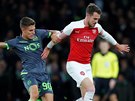 Aaron Ramsey (vpravo) z Arsenalu atakovaný Miguelem Luisem ze Sportingu Lisabon.