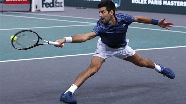 Srb Novak Djokovič se ve finále turnaje v Paříži snaží v krkolomné pozici vrátit míč zpět na opačnou stranu kurtu.