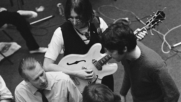John Lennon, Paul McCartney, George Harrison (s kytarou zády) a Ringo Starr ve studiu s producentem Georgem Martinem.