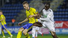 Pavel Vyhnal ze Zlína (vlevo) pihrává, brání ho Soufiane Dramé z Karviné.