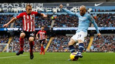 David Silva z Manchesteru City (vpravo) se snaí odcentrovat pes Jamese Warda...