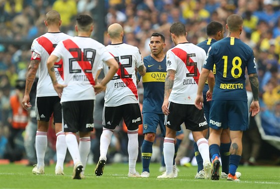 Carlos Tevez v dresu Boky Juniors si podává ruku s protihráem Javierem Pinolou...