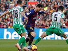 Lionel Messi z Barcelony (uprosted) klikuje mezi protihrái z Realu Betis...