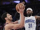 Enes Kanter (vlevo) z New Yorku útoí kolem  Terrence Rosse z Orlanda.