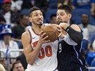 Enes Kanter (00) z New Yorku se tlaí kolem Nikoly Vuevie z Orlanda.