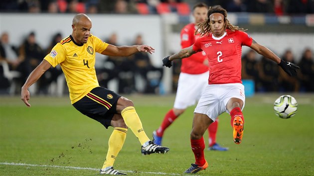 Vincent Kompany z Belgie (vlevo) a Kevin Mbabu ze vcarska v souboji o m.