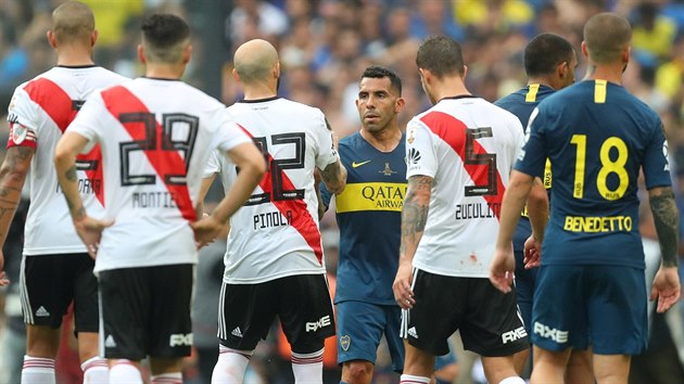 Carlos Tevez v dresu Boky Juniors si podv ruku s protihrem Javierem Pinolou z River Plate.