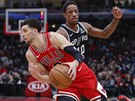 Zach LaVine (v ervené) u Chicaga útoí kolem DeMara DeRozana ze San Antonia.