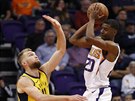 Josh Jackson (v bílém) z Phoenixu pihrává kolem  Domantase Sabonise z Indiany.