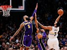 Trey Lyles (v bílém¨) z Denveru atakuje ko LA Lakers pes Tysona Chandlera...