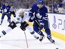 Auston Matthews z Toronta (vpravo) u puku, dotírá na nj Tomá Hertl ze San...