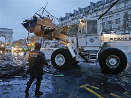 Buldozer likviduje následky demonstrace lutých vest. (25. listopadu 2018)