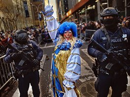A clown performs as heavily armed police stand guard along Sixth Avenue during...
