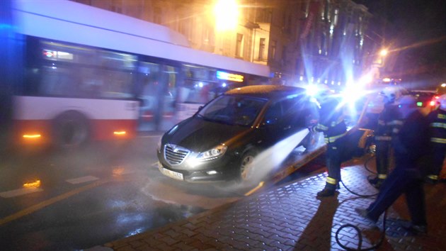 Hasiči omývají auto, které v ústecké Masarykově ulici vjelo do čerstvé betonové směsi.
