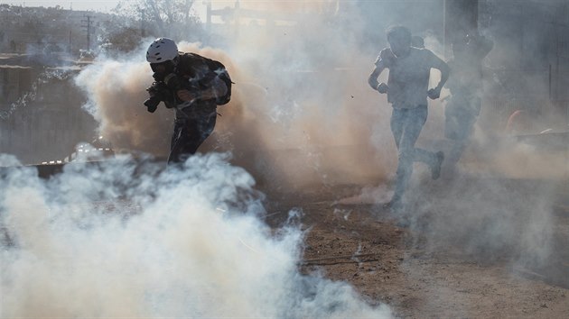 Migranti utkaj ped slznm plynem vyplenm americkmi policisty pi incidentu, kdy se velk skupina migrant pokusila nsiln pekroit hranici do USA. (25. listopadu 2018)