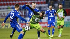 Útočník Mladé Boleslavi Nikolaj Komličenko (uprostřed) si kryje míč před...