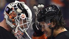 Calvin Pickard (vlevo) a Travis Konecny oslavují výhru Philadelphie.