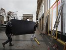 Pracovníci opevují výlohu luxusního obchodu na Champs-Élysées v Paíi v...