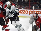 Erik Karlsson ze San Jose (v bílém) (65) nepromnil anci ped brankou Ottawy.