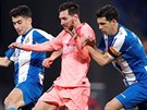 Lionel Messi prochází s míem mezi bránícími hrái Espanyolu.