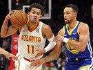 Trae Young (vlevo) z Atlanty se prodírá kolem Stephena Curryho z Golden State.