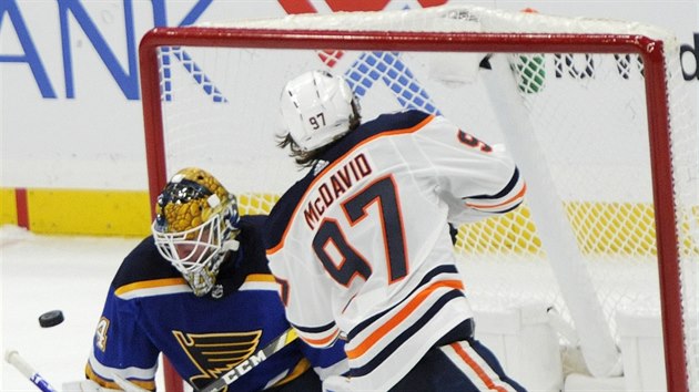 Connor McDavid (97) z Edmontonu prostelil glmana Jakea Allena ze St. Louis.