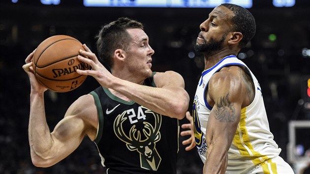 Pat Connaughton (vlevo) z Milwaukee pod tlakem Andreho Iguodaly z Golden State.