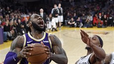 LeBron James (vlevo) z LA Lakers útoí kolem Danteho Cunninghama ze San Antonia.