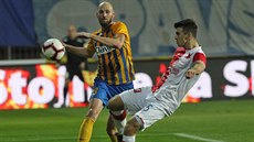 Slávistický obránce Ond�ej Kúdela odkopává balon p�ed opavským forvardem...