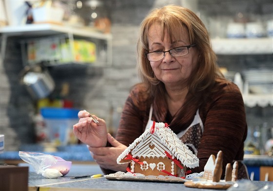 Perníkáka Ilona Lazúrová zdobí perníkovou chaloupku.