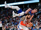 Mason Plumlee (nahoe) z Denveru padá na Stevena Adamse z Oklahoma City.