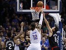 Steven Adams (12) z Oklahoma City se prosazuje pod koem LA Clippers, bránili...