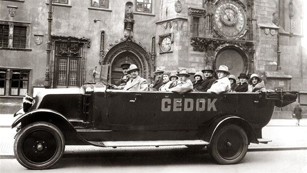 Automobil cestovní kanceláře Čedok s turisty pod pražským orlojem (1931)