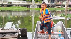 Do koly na lodi. Ptiletý kluk z Bangkoku umí sám kormidlovat lun.