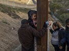 Migranti pekonávají hraniní plot na americko-mexické hranici. (27. prosince...