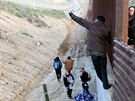 Migranti pekonávají hraniní plot na americko-mexické hranici. (27. prosince...