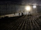 Migranti pekonávají hraniní plot na americko-mexické hranici. (26. prosince...