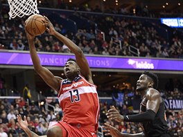 Thomas Bryant (13) z Washingtonu útoí na ko Phoenixu kolem Deandreho Aytona.