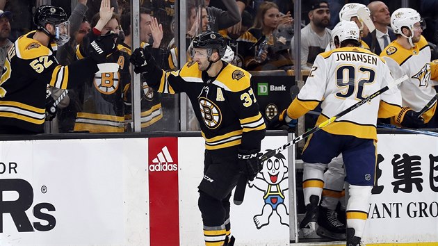 Patrice Bergeron z Bostonu se raduje se svmi spoluhri ze vstelenho glu v utkn proti Nashvillu.