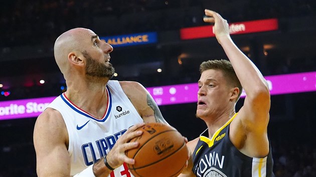 Marcin Gortat (vlevo) z LA Clippers zakonuje pes Jonase Jerebka z Golden State.