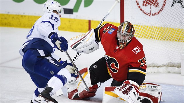 David Rittich v brance Calgary zasahuje proti stele Ondeje Palta z Tampy.