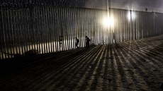 Migranti překonávají hraniční plot na americko-mexické hranici. (26. prosince...