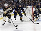 David Pastrák z Bostonu u puku, stíhá ho Rasmus Ristolainen z Buffala.