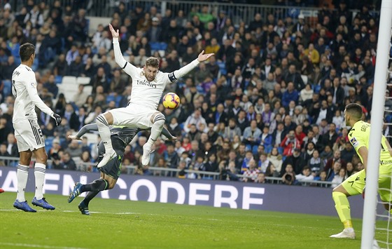 Sergio Ramos z Realu Madrid (ve výskoku) se snaí v akrobatické pozici...