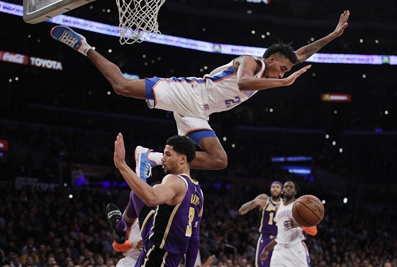 Terrance Ferguson (nahoe) z Oklahoma City nepíjemn padá po stetu s Joshem...