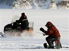 Rybá loví ryby na zamrzlém jezee v Krasnojarsku. (3. ledna 2019)